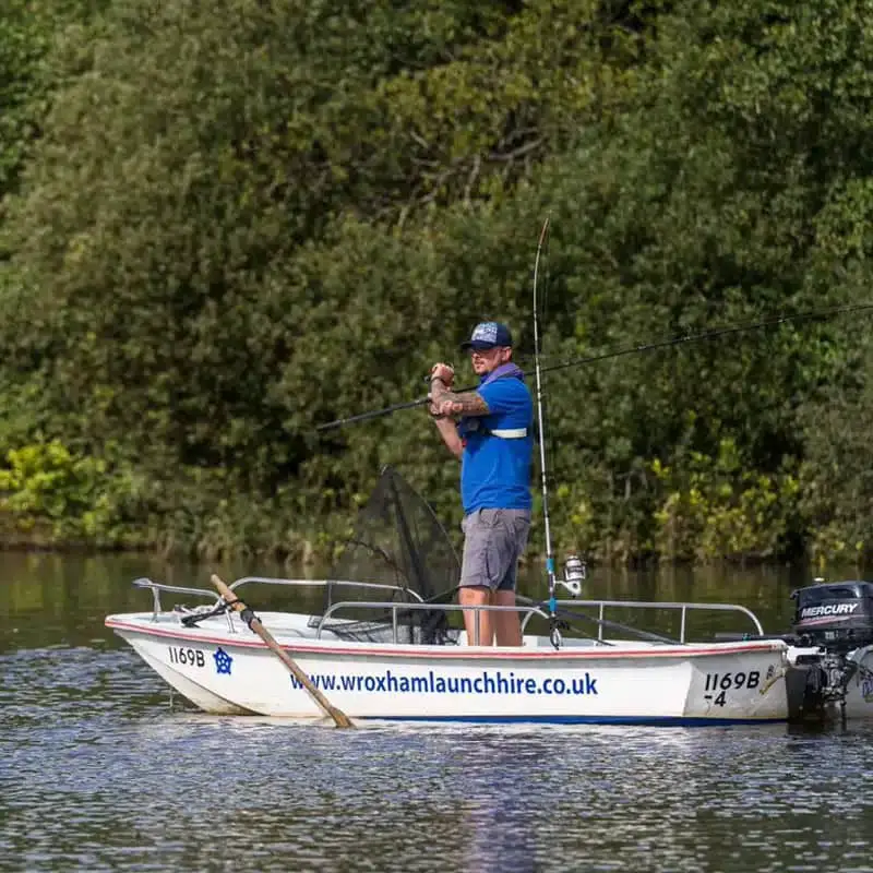"Image showcasing a fishing boat in Wroxham, set against the scenic backdrop of the Norfolk Broads. The boat is equipped for angling adventures in this picturesque fishing destination."